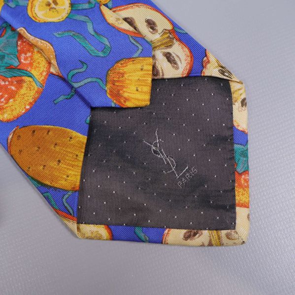 Innerfodret på slipsen med prickigt mönster och YSL-brodyr