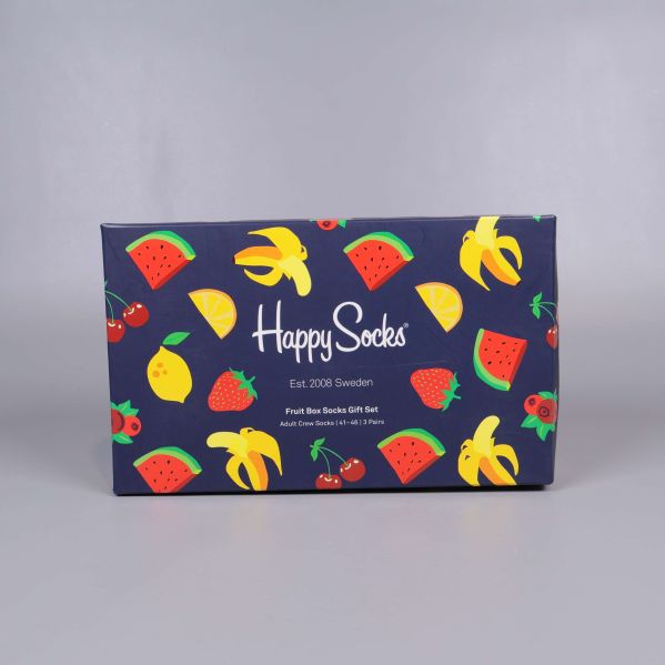 Presentförpackning Happy Socks dekorerad med fruktmotiv mot grå bakgrund
