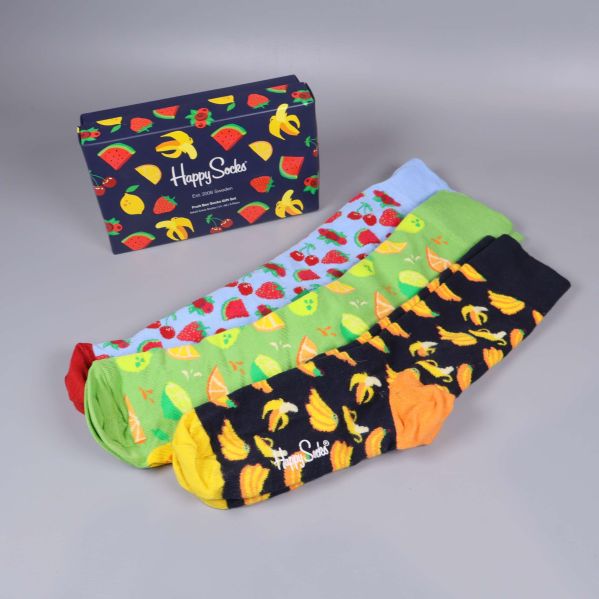 Tre färgglada strumpor utlagda bredvid presentförpackning