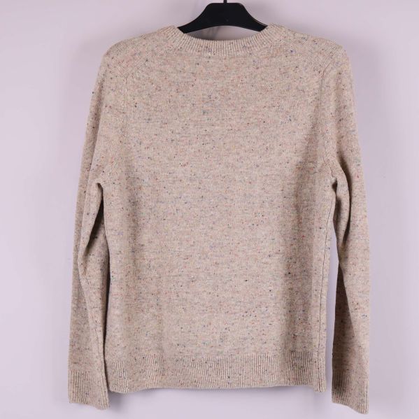 Baksida på beige melerad stickad tröja hänger på galge