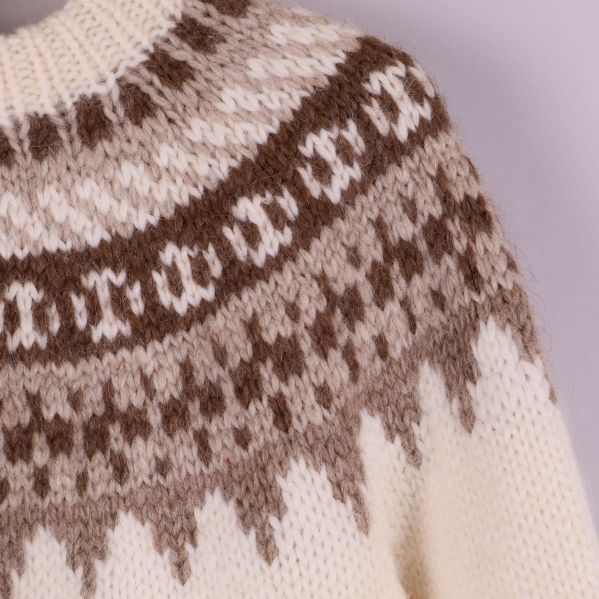 Närbild på tröjans ok med brunt och beige mönster