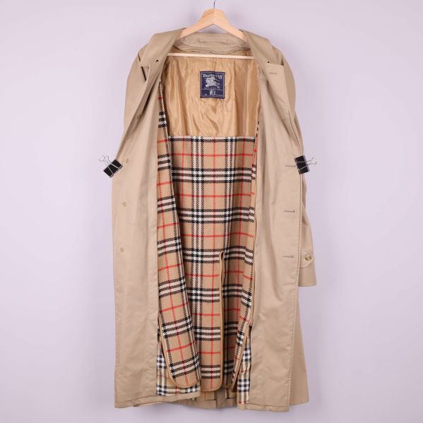 Trenchcoaten uppknäppt visar rutigt foder