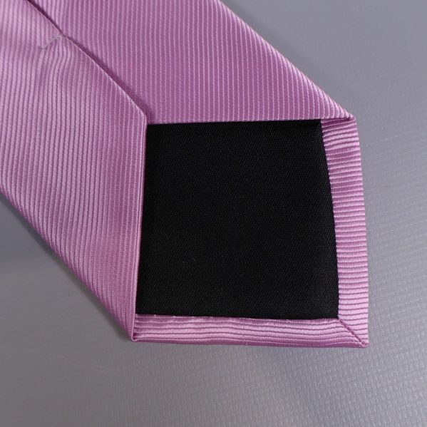 Detalj på spetsen av lila slips med svart foder