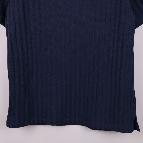 Nedre delen av blå ribbad pikétröja visas