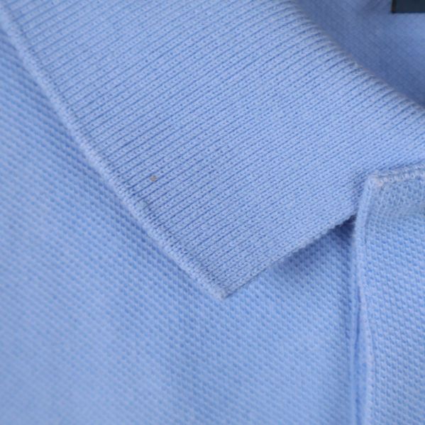 Närbild på ljusblå pikékrage