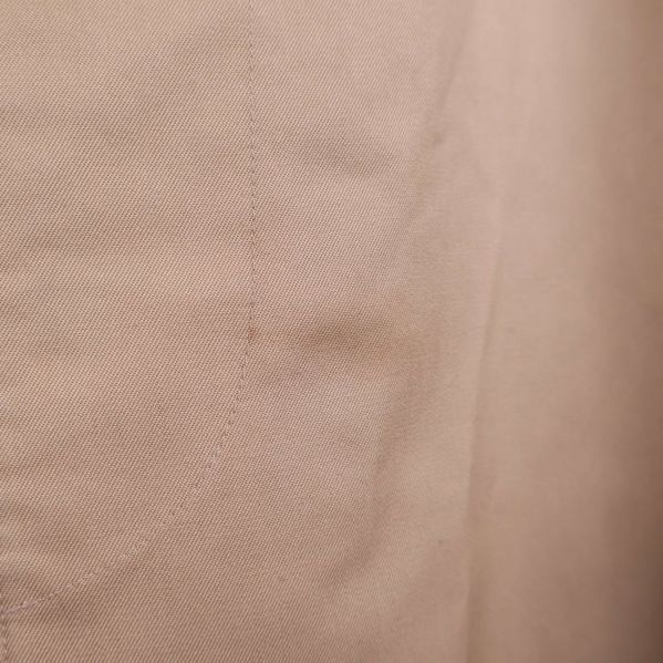 Närbild på liten fläck på trenchcoatens framsida