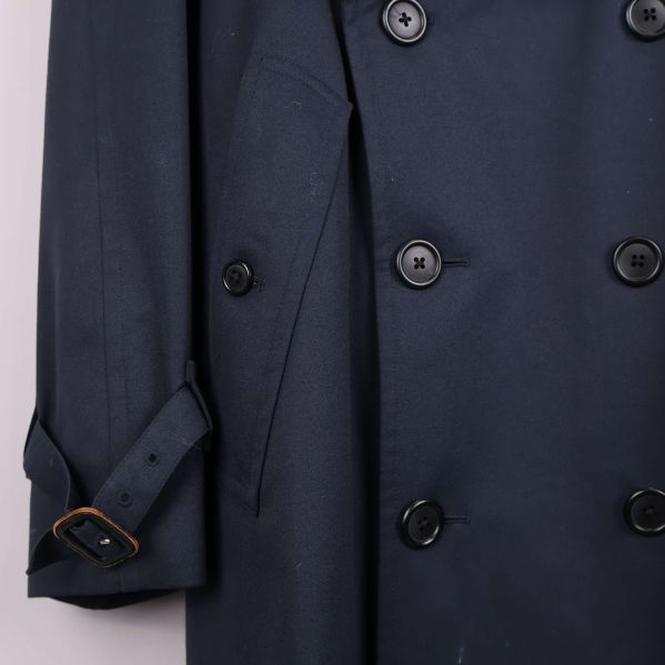 Närbild på ficka och knappar på trenchcoat