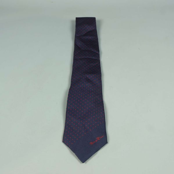 Mörkblå slips med röda prickar utlagd