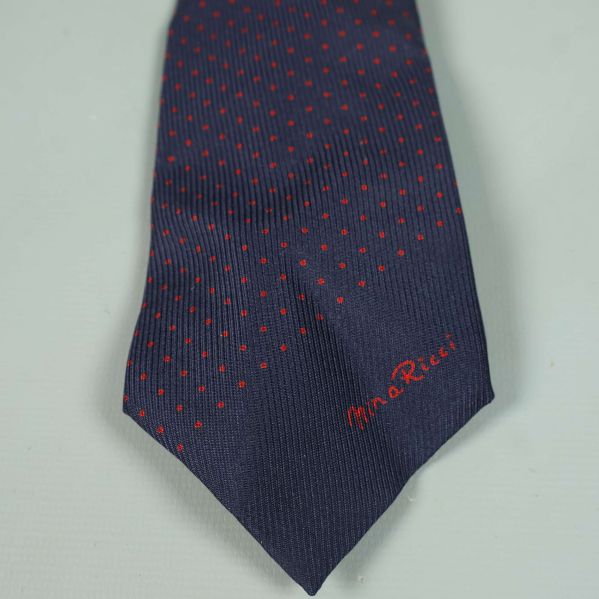 Närbild på spetsen av slipsen med broderad logotyp