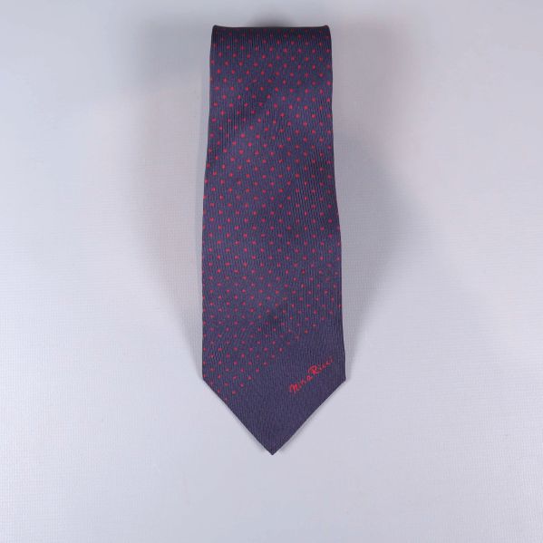 Mörkblå slips med små röda prickar, liggande platt