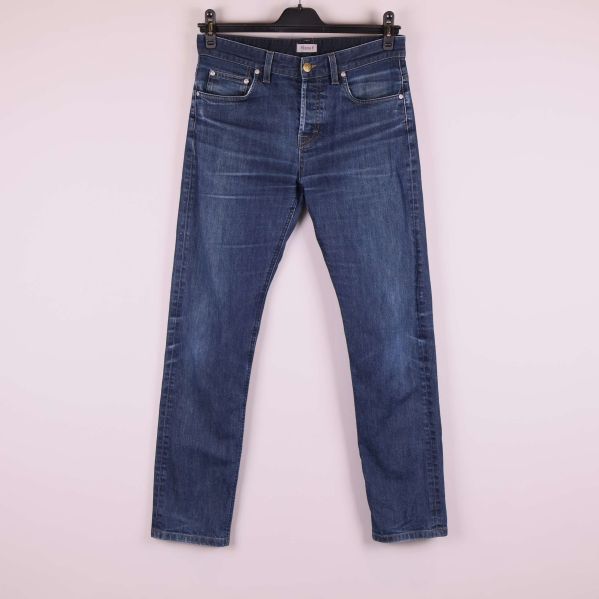 Framsida av raka blå jeans hängande på galge