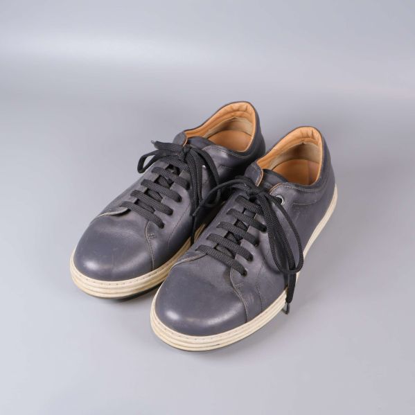 Ett par svarta låga sneakers med svarta snören