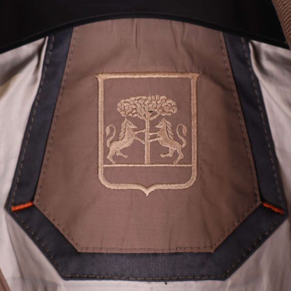 Broderat emblem med lejon och träd i nacken på jackans insida