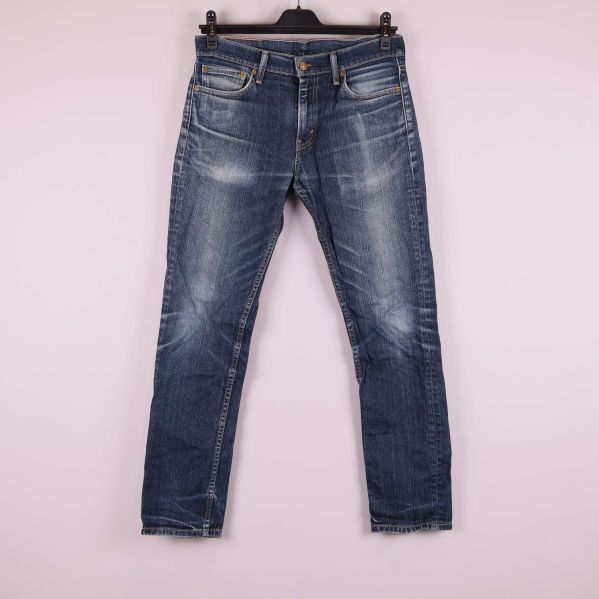 Jeans framifrån med knappgylf och slitna detaljer