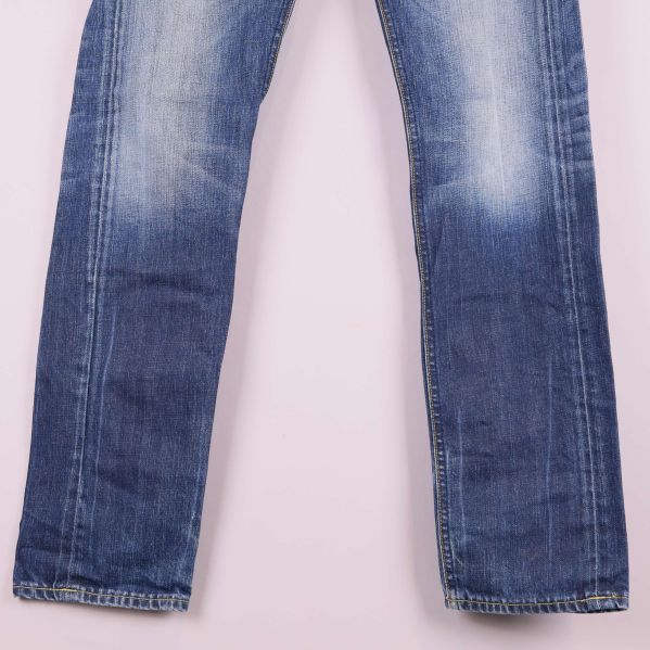 Benparti på blåa jeans med slitningsdetaljer