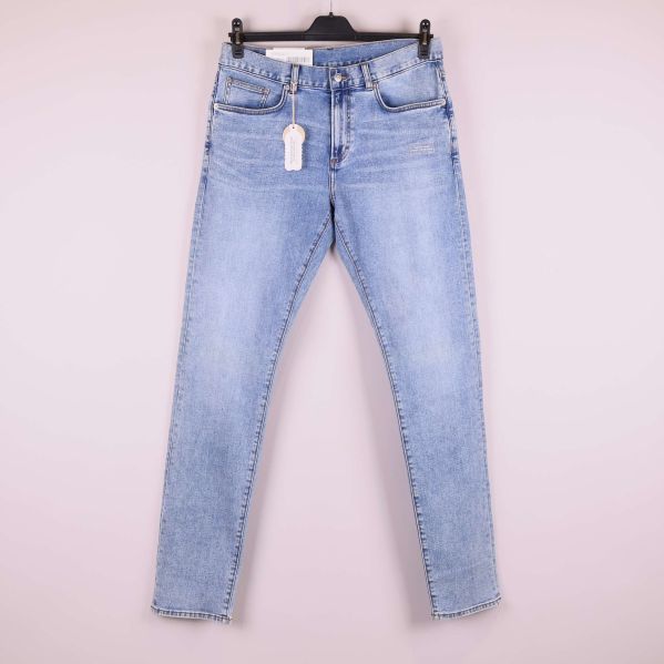 Jeans i ljus denim upphängda på galge, helbild framifrån