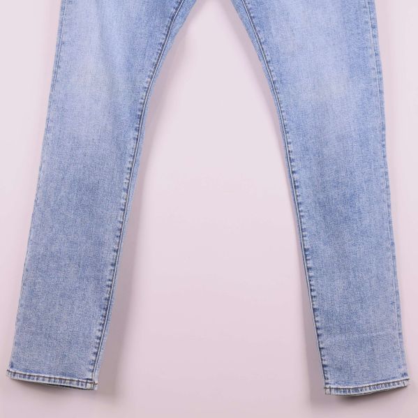 Närbild på de nedre delarna av benen på ljusa jeans