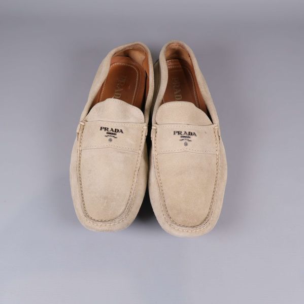 Beige mockaloafers från Prada framifrån med logotyp