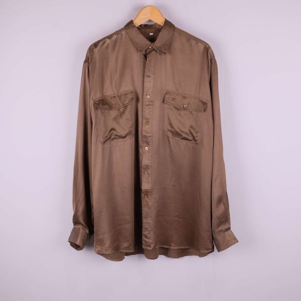 Brun silkesskjorta upphängd framifrån med bröstfickor
