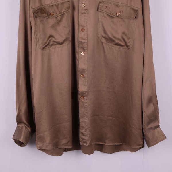 Nedre delen av brun silkesskjorta och knapprad