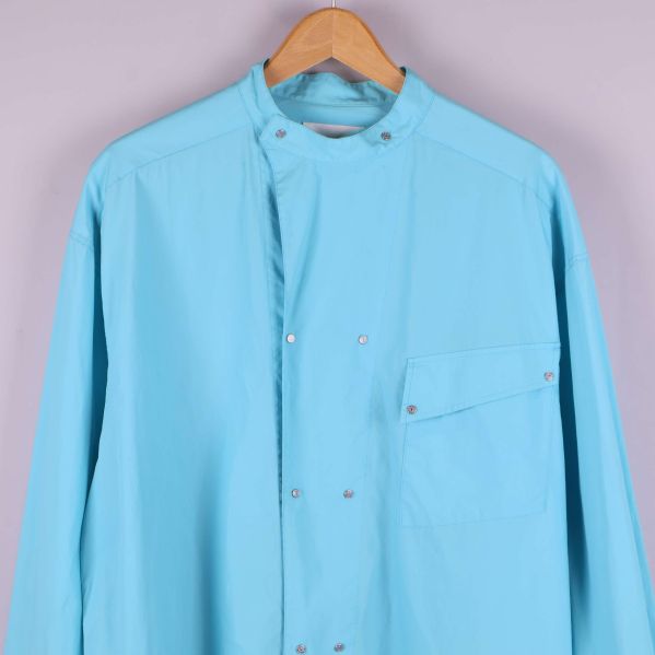 Framstycke och bröstficka på ljusblå skjorta med tryckknappar