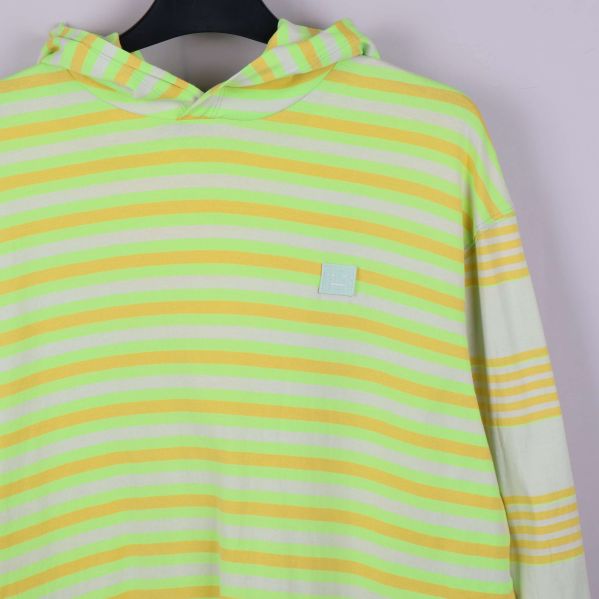 Närbild på randig huva och logomärke på bröstet