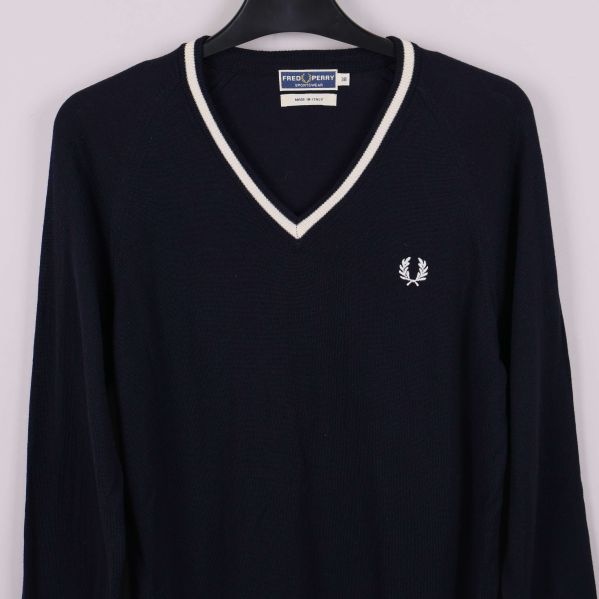 Detalj på V-ringning och bröstlogo på tröja