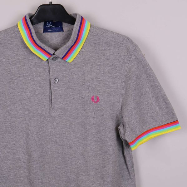 Närbild på pikétröjans krage och ärm med regnbågsdetaljer