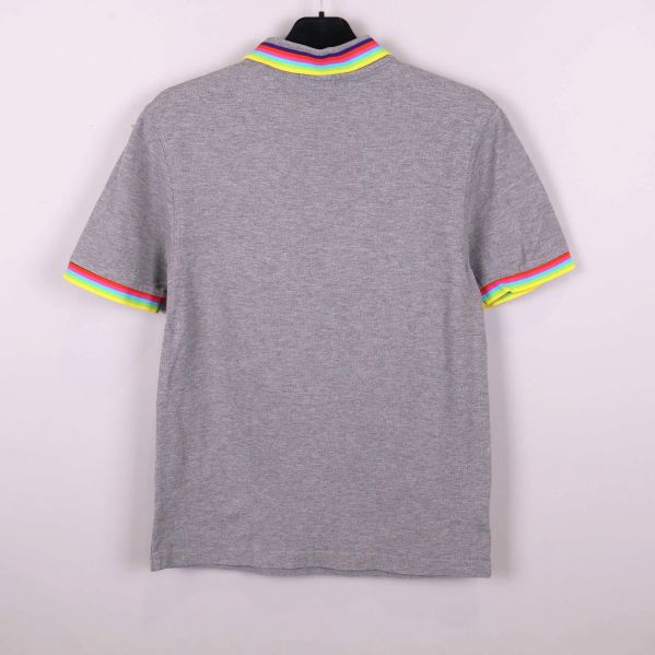 Baksidan av grå pikétröja med randiga ärmslut och krage