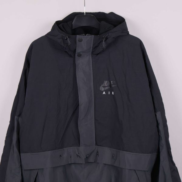 Närbild på Nike Air logotyp och tryckknappar på jackans framsida