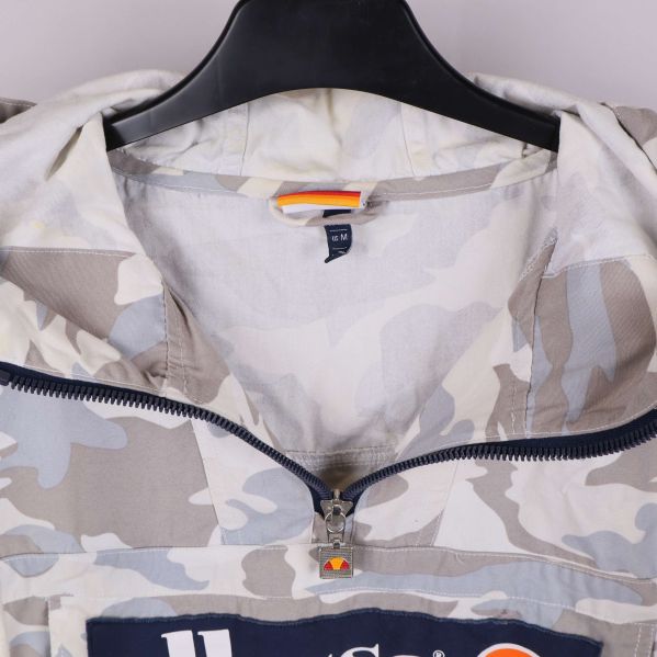 Närbild på dragkedja och krage med camouflage