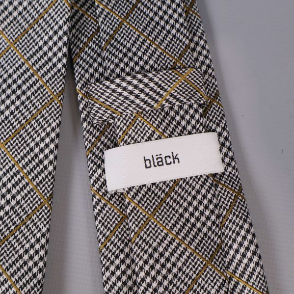 Närbild på etikett med texten bläck på kravatt