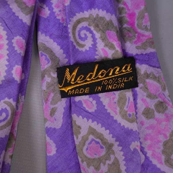 Närbild på svart etikett som anger Medona 100% silke