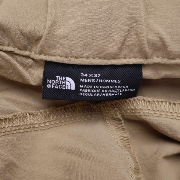 Etikett från The North Face i byxans midja visar storlek 34x32