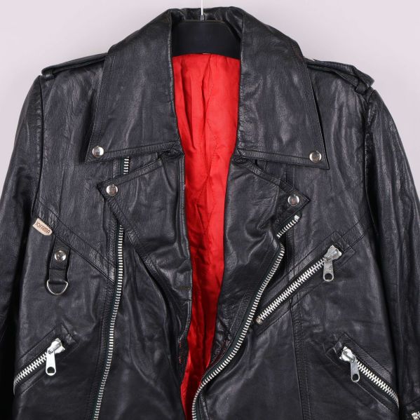 Framstycke av svart skinnjacka med synliga dragkedjor och knappar