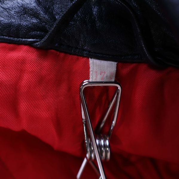 Närbild på jackans röda foder och liten tvättlapp