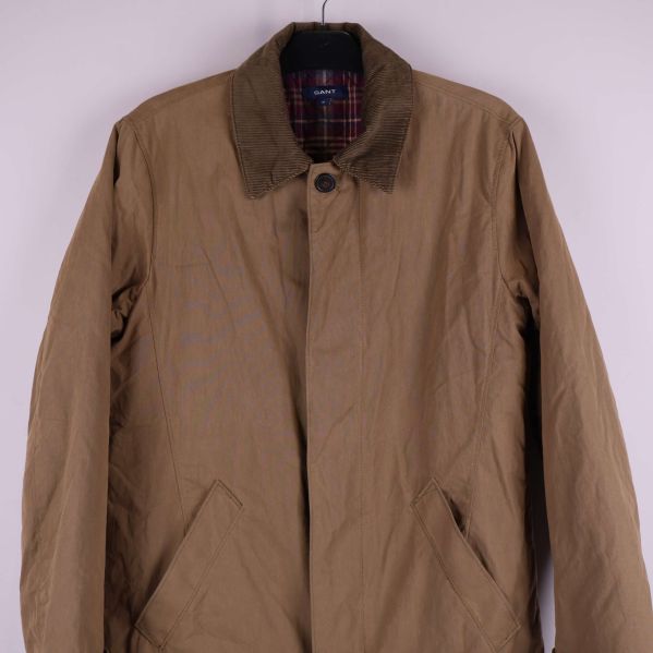 Halvbild på jackans framsida, synliga fickor och knappar