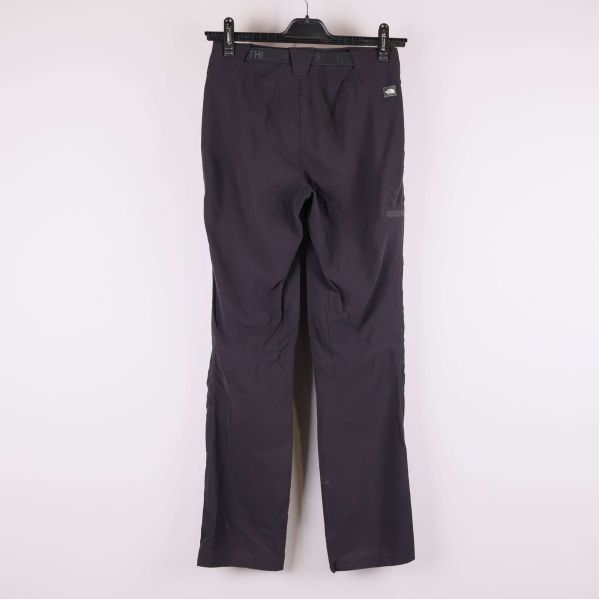 Baksidan av mörka byxor visas hängande mot ljus bakgrund