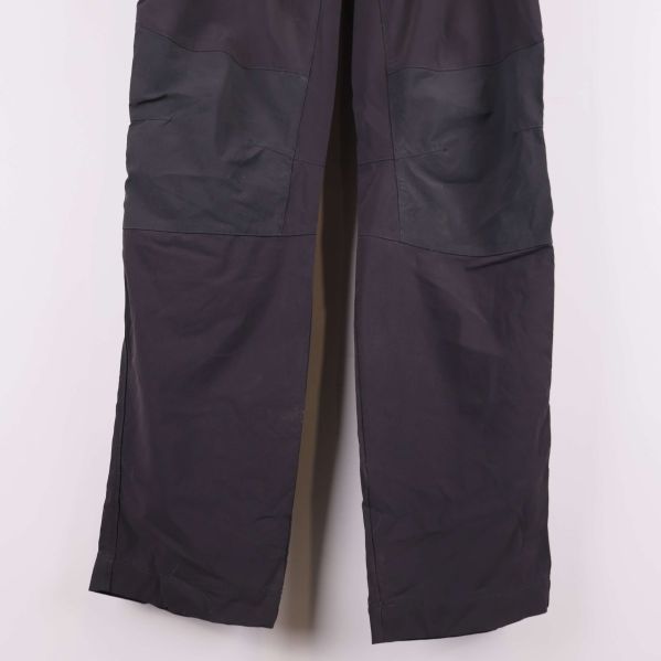 Förstärkta knäpartier på mörka byxor i närbild