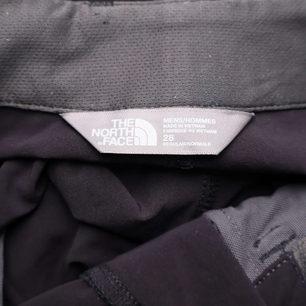 Närbild på The North Face-loggan i midjan på byxorna