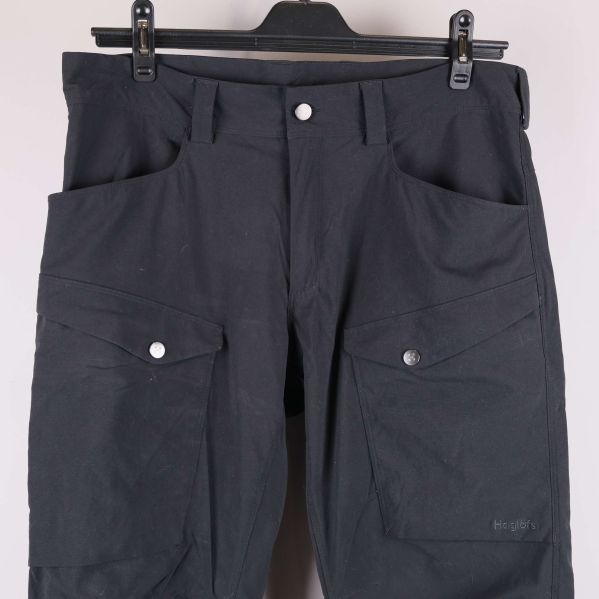 Byxornas övre framdel med synliga fickor och knäppning