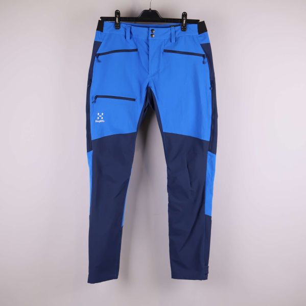 Framsidan av blå funktionsbyxor med svarta dragkedjor