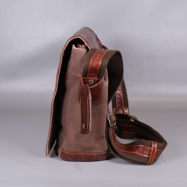 Sida av canvasväska med läderrem och blixtlås