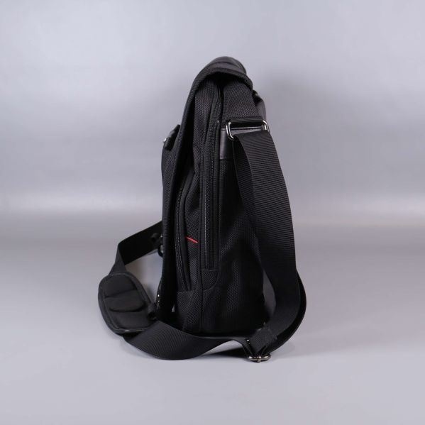 Väskans sida med dragkedjor och justerbar rem