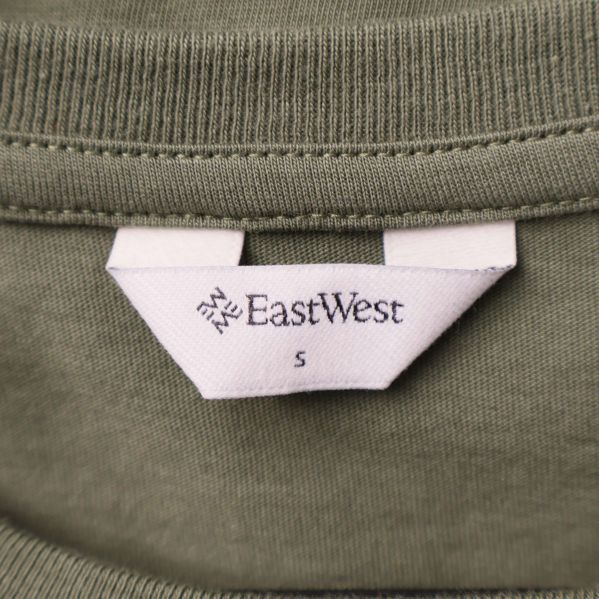 Närbild av nacketikett på t-shirt med texten EastWest S