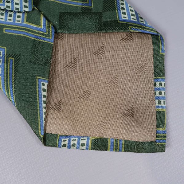 Detalj av slipsens spets och innertyg med broderade symboler