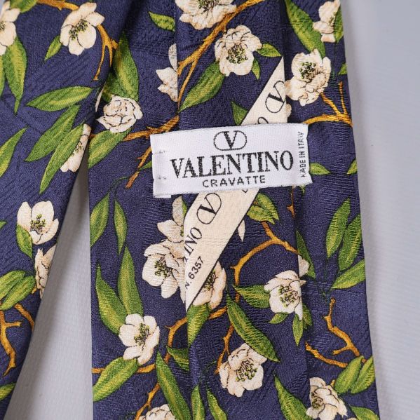 Närbild på Valentino märkesskylt på slipsen