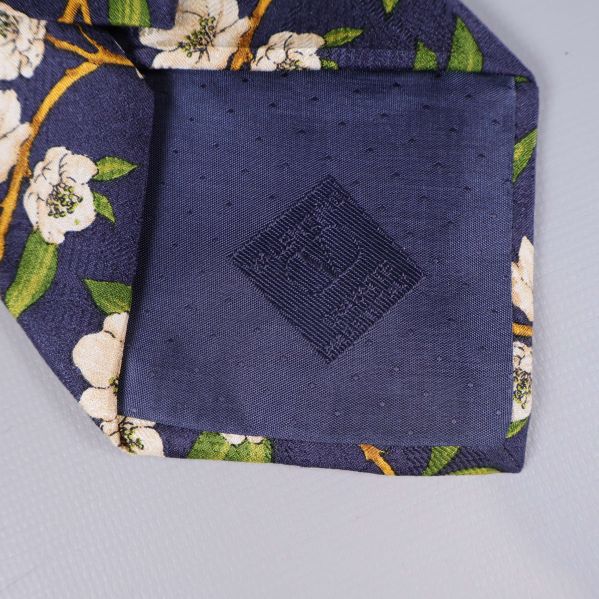 Närbild på spetsen av slipsen med brodyr