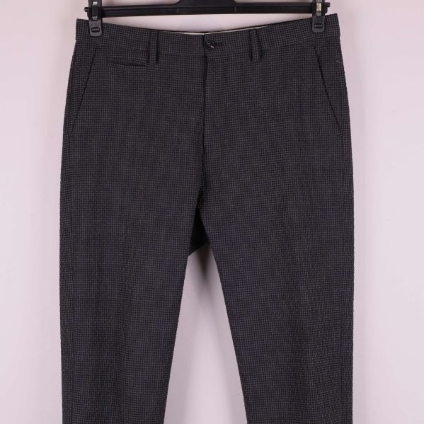 Närbild på överdel och fickdetaljer av byxorna