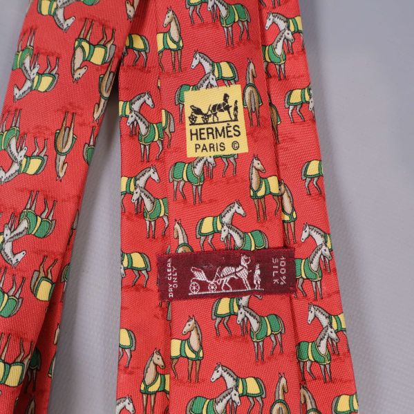 Närbild på Hermès Paris etikett och hästmönster på slips